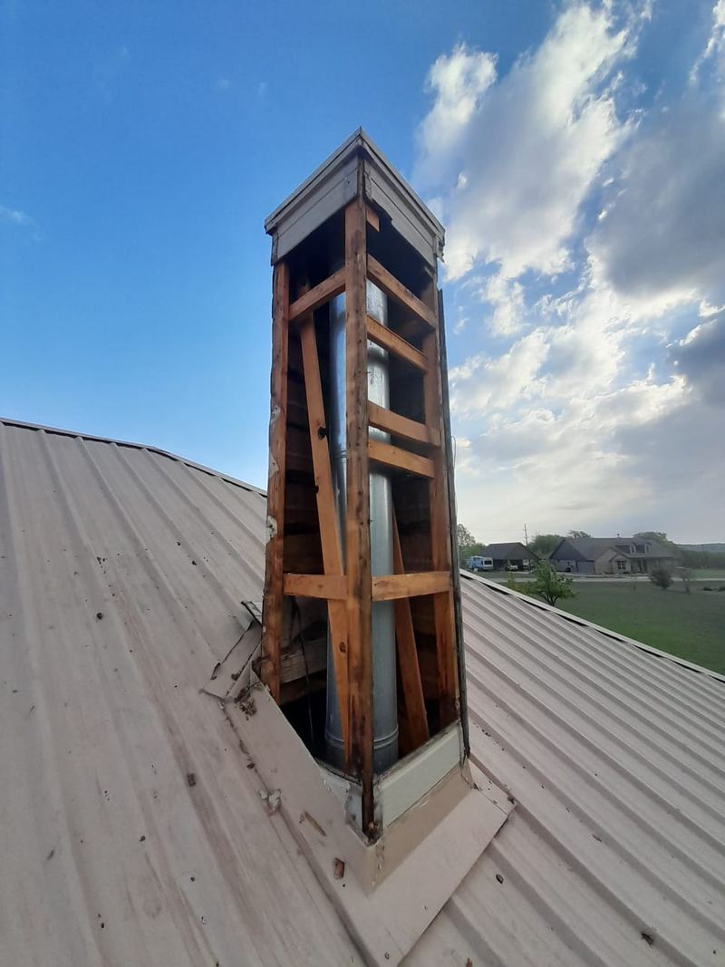 Exposed timber framing on a chimney chase before new sheathing and siding are fitted