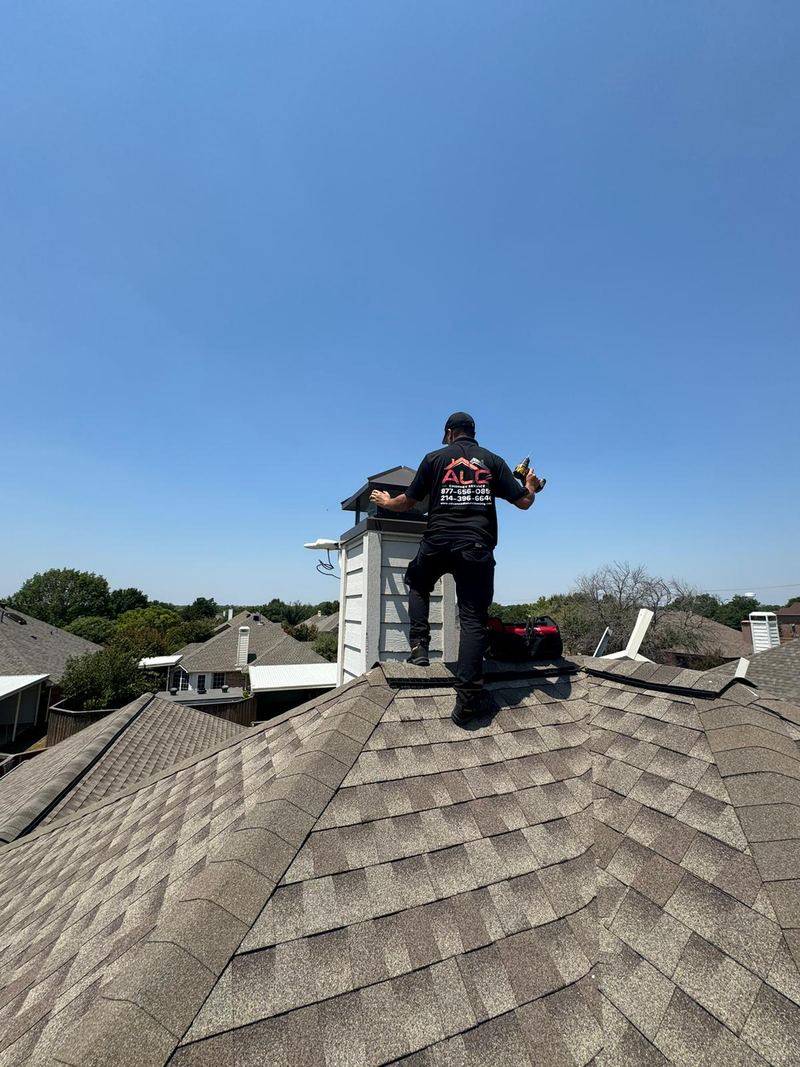 An ALC chimney technician working beside a chimney on a residential roof